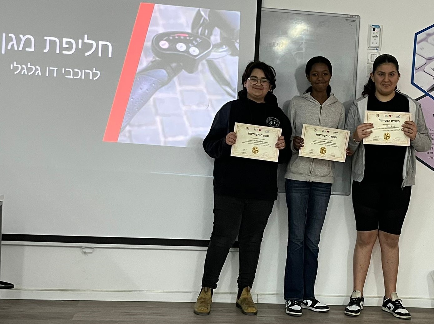 שלוש תלמידות אוחזות בתעודה